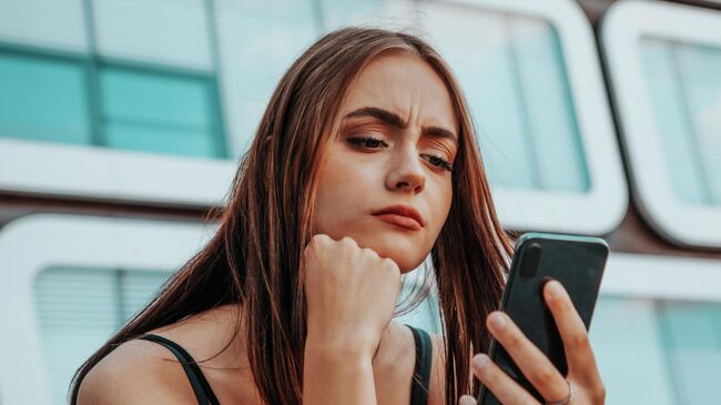 Девушка проверяет свой телефон Девушка проверяет свой телефон