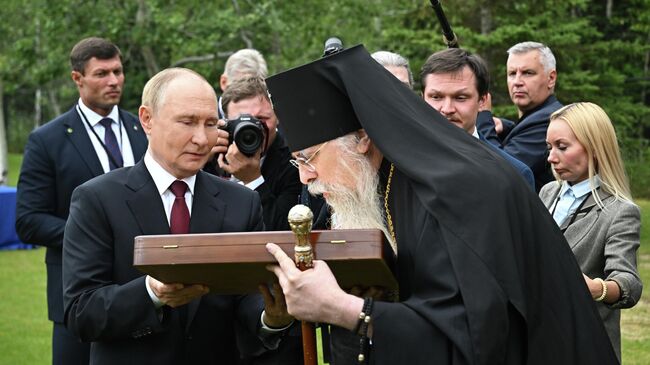 Президент РФ Владимир Путин и архиепископ Ситкинский и Аляскинский Алексий после возложения цветов к могилам советских воинов на мемориальном кладбище Форт Ричардсон на Аляске