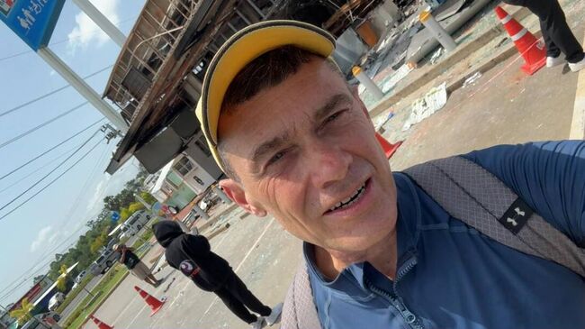 Тимур Збарский на фоне магазина на заправке в Таиланде после артобстрела со стороны Камбоджи