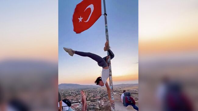 Туристка на флагштоке в Турции