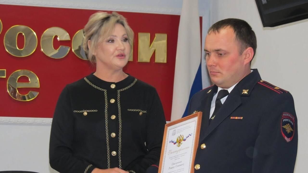 Виктория вручает благодарственную грамоту одному из полицейских - РИА Новости, 1920, 27.08.2025