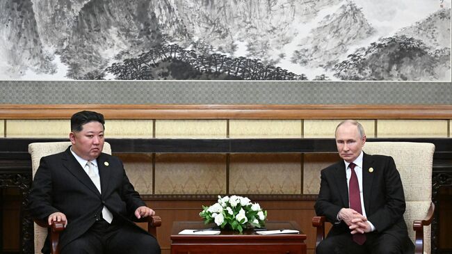 Президент России Владимир Путин и председатель государственных дел КНДР Ким Чен Ын во время встречи в Пекине