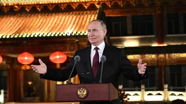 Президент РФ Владимир Путин во время подхода к представителям СМИ в резиденции Дяоюйтай в Пекине