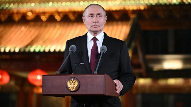 Президент РФ Владимир Путин во время подхода к представителям СМИ в резиденции Дяоюйтай в Пекине