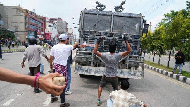 Протестующие перед бронированной машиной возле здания парламента в Катманду, Непал