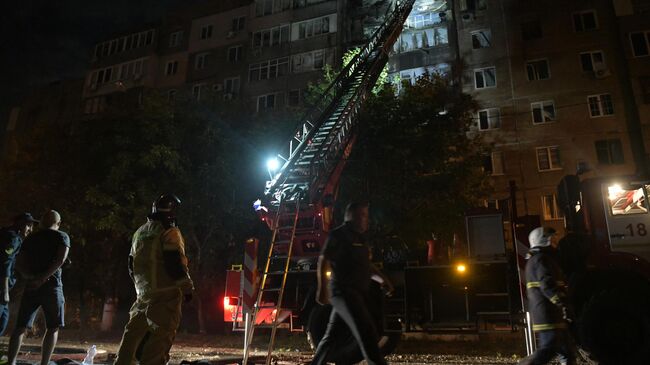 Сотрудники МЧС РФ осматривают многоквартирный жилой дом, поврежденный в результате обстрела Макеевки со стороны ВСУ. 8 сентября 2025