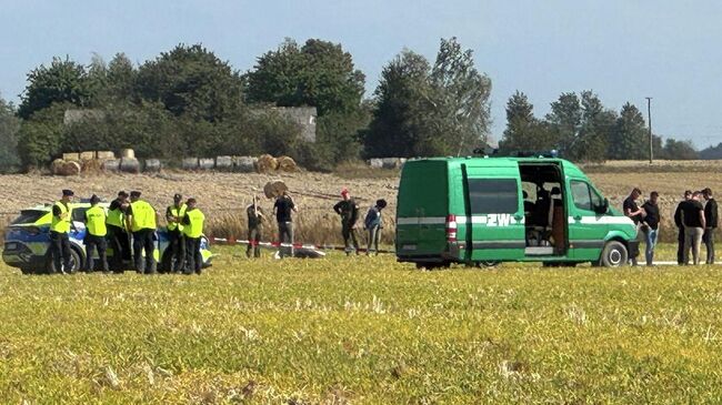 Сотрудники правоохранительных органов и военные на месте обнаружении сбитого беспилотника в населенном пункте Вохынь, Польша