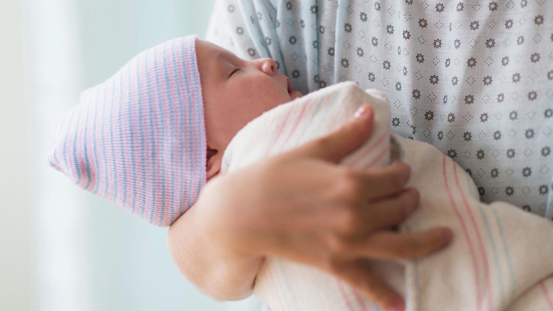 Женщина держит на руках новорожденного ребенка - РИА Новости, 1920, 12.09.2025