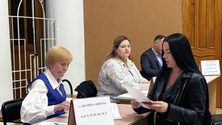 Женщина на выборах губернатора Еврейской автономной области на избирательном участке в городском дворце культуры в Биробиджане