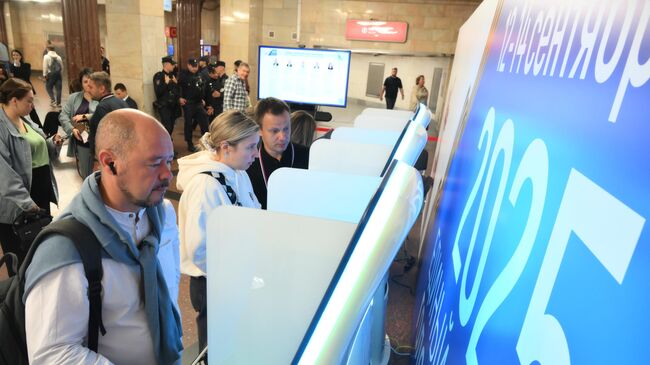 Люди голосуют на выборах глав 19 регионов РФ через терминалы электронного голосования в вестибюле станции метро Курская Арбатско-Покровской линии в Москве. 12 сентября 2025