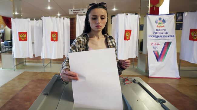 Девушка голосует на выборах губернатора Краснодарского края на избирательном участке в Краснодарской филармонии