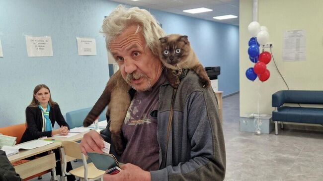 Мужчина с котом голосует на избирательном участке на выборах губернатора Свердловской области Мужчина с котом голосует на избирательном участке на выборах губернатора Свердловской области
