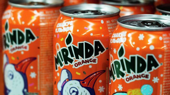 Банки Mirinda на полке в супермаркете