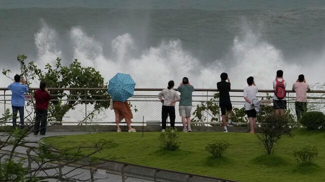 Местные жители наблюдают за волнами перед приходом супертайфуна Рагаса в Шэньчжэне, Китай