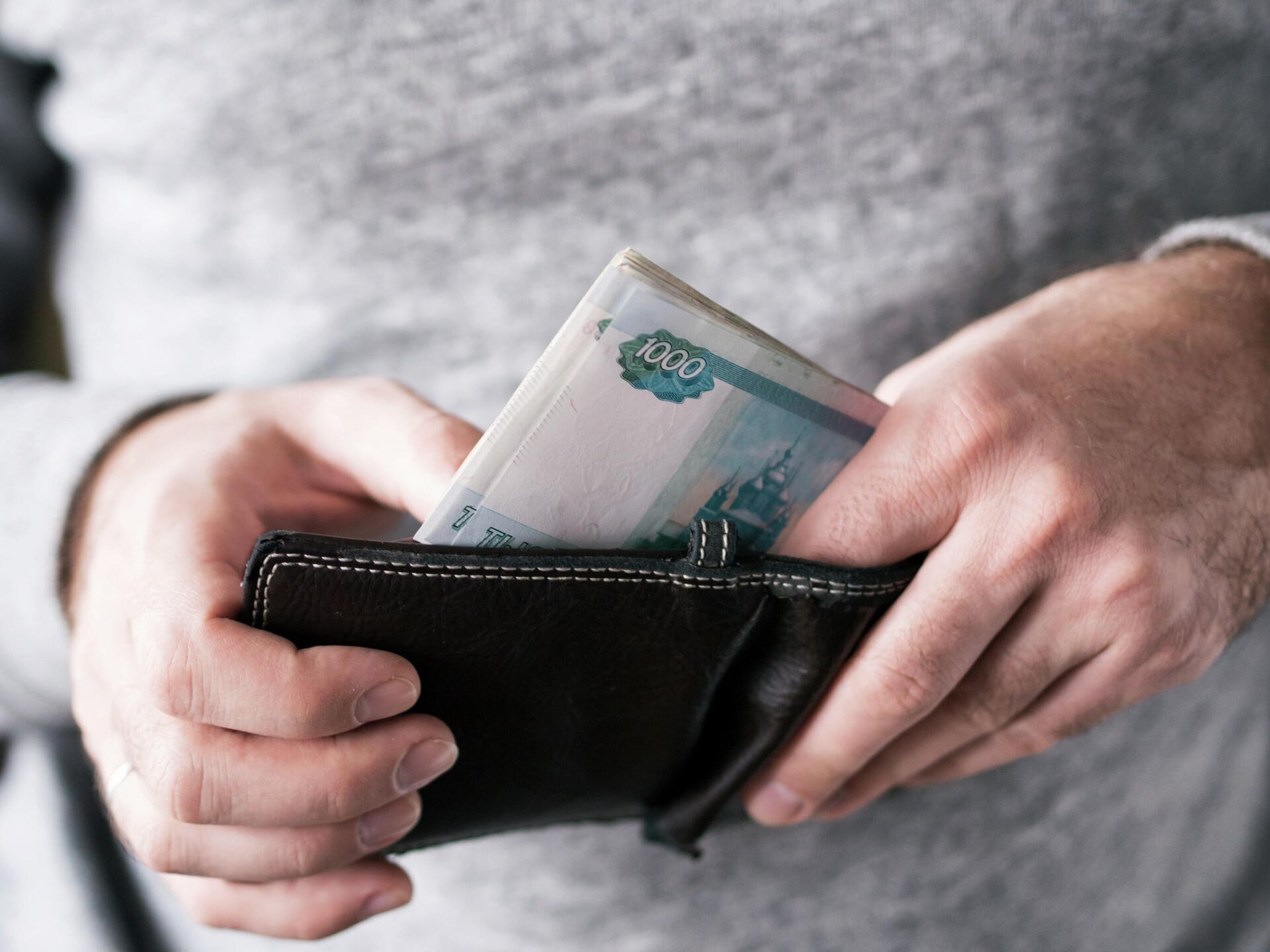 Мужчина достает деньги из кошелька Мужчина достает деньги из кошелька - РИА Новости, 1920, 09.12.2025