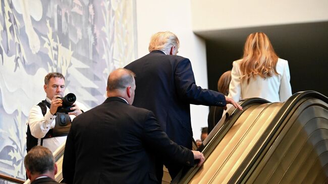 Президент США Дональд Трамп и первая леди Меланья Трамп поднимаются по эскалатору во время прибытия на 80-ю сессию Генеральной Ассамблеи ООН