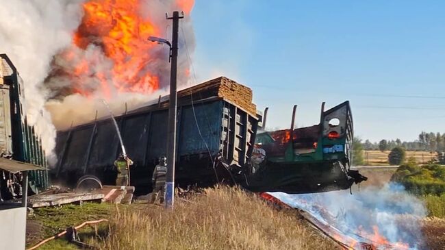 Сотрудники МЧС ликвидируют пожар на месте столкновения грузовика и товарного поезда в Смоленской области