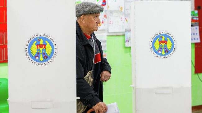 Мужчина голосует на избирательном участке в Кишиневе