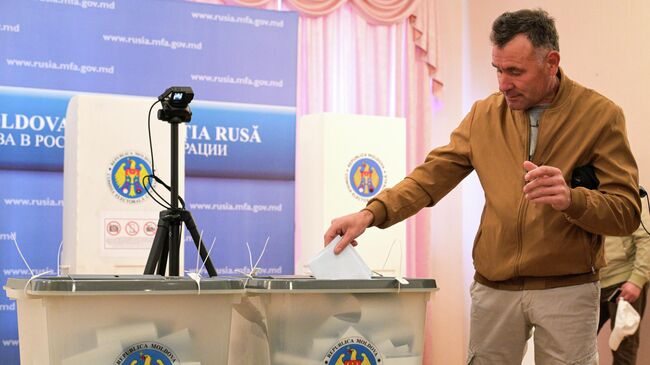 Мужчина голосует на избирательном участке в посольстве Республики Молдавия в Москве на парламентских выборах