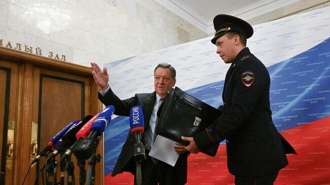 Председатель комитета Государственной Думы РФ по бюджету и налогам Андрей Макаров и офицер Государственной фельдъегерской службы РФ во время пресс-подхода в Государственной Думе РФ после внесения Правительством РФ проекта федерального бюджета на 2026 год и плановый период 2027-2028 годов