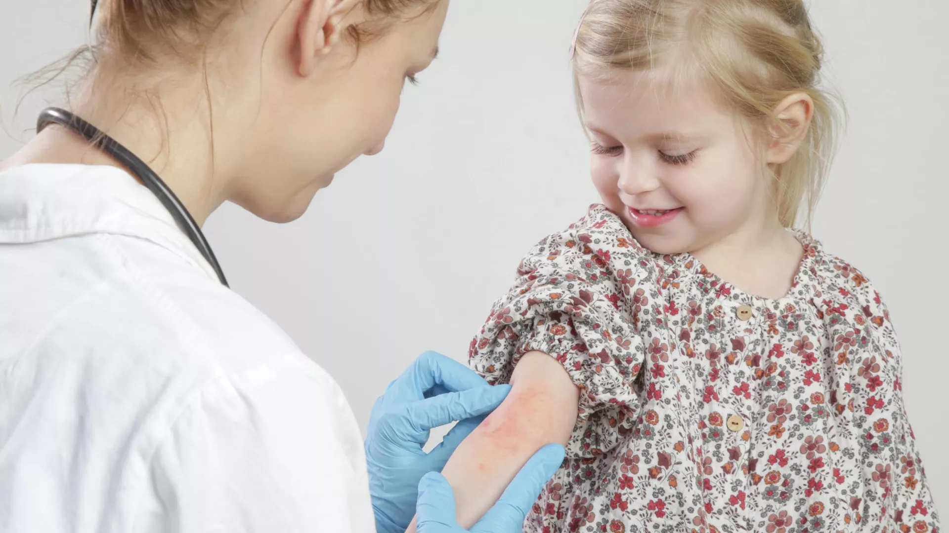 A doctor examines a child with dermatitis