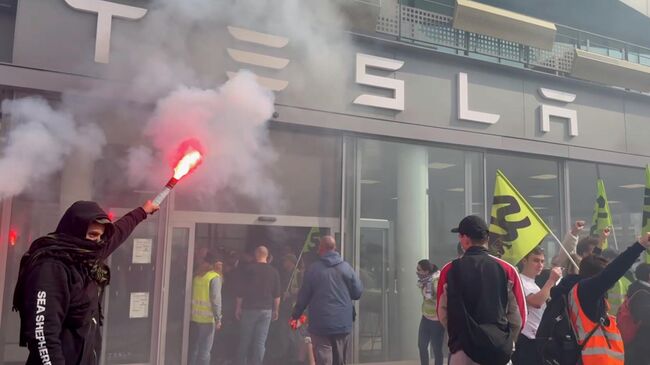 Протестующие в автосалоне Tesla в Париже