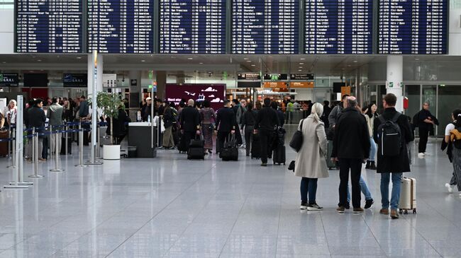 Пассажиры перед информационным табло в аэропорту Мюнхена после сообщений о дронах в воздушном пространстве. 3 октября 2025