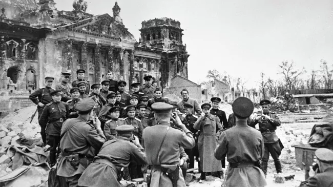 Военные корреспонденты фотографируются у стен поверженного Рейхстага, Берлин, 5 мая 1945 года