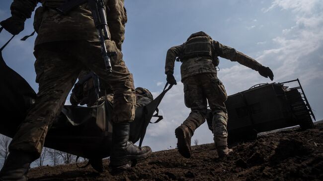 Украинские военные эвакуируют раненого