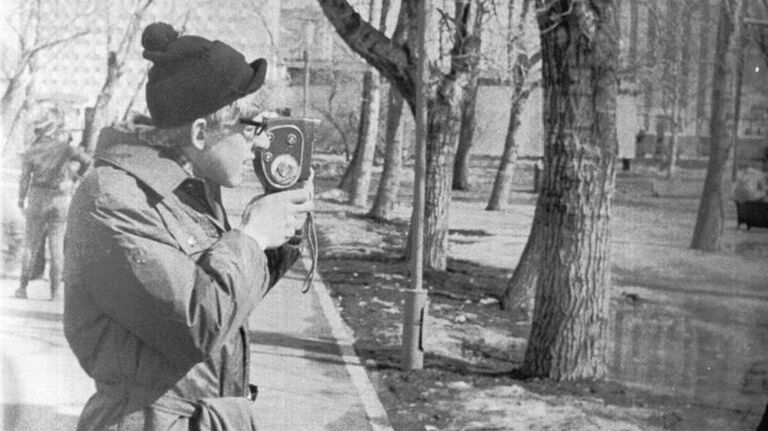 Это 1978 год. Человек с киноаппаратом. Получив в подарок киноаппарат, Кудрин снимал все вокруг. В данном случае - хронику первомайской демонстрации.