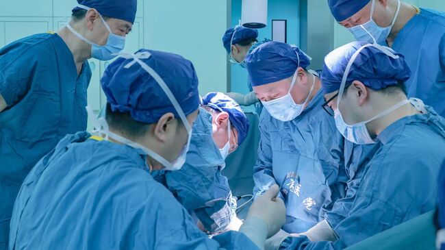 Китайские хирурги из больницы Сицзинь при Медицинском университете ВВС проводят трансплантацию печени генетически модифицированной свиньи