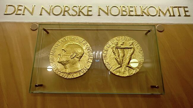 Лицевая и оборотная стороны медали Нобелевской премии мира