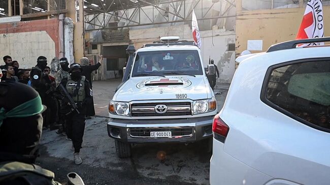 Члены ХАМАС передают часть из 20 израильских заложников представителям Международного комитета Красного Креста в Газе. 13 октября 2025