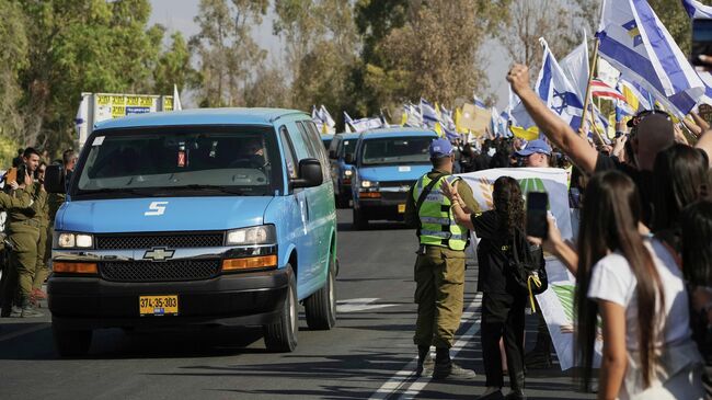 Автомобили с освобожденными из сектора Газа заложниками на военной базе недалеко от Рейма на юге Израиля
