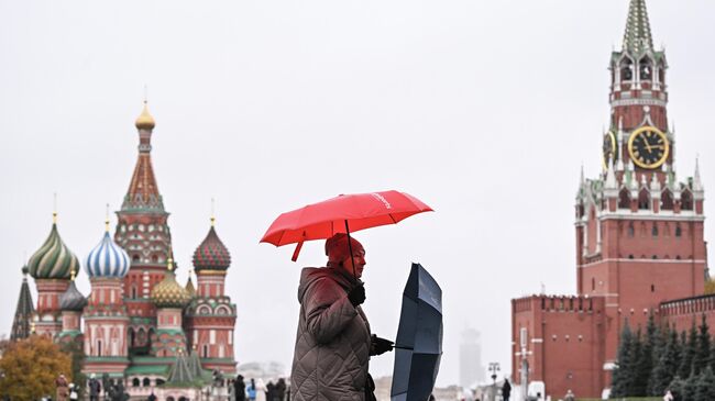 Женщина во время дождя на Красной площади в Москве