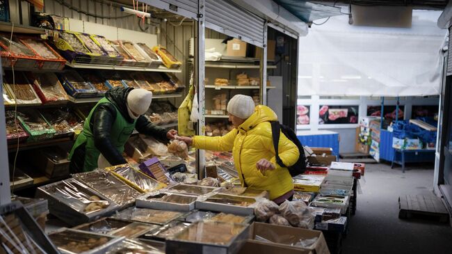 Женщина покупает продукты на рынке в Киеве, Украина