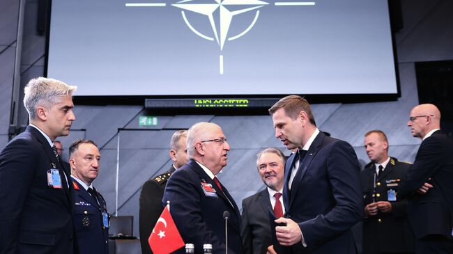 Эстонский министр обороны Ханно Певкур (справа) перед началом заседания глав минобороны НАТО. 15 октября 2025