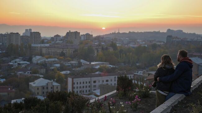 Молодые люди наблюдают за закатом с архитектурно-монументального комплекса Каскад Молодые люди наблюдают за закатом с архитектурно-монументального комплекса Каскад