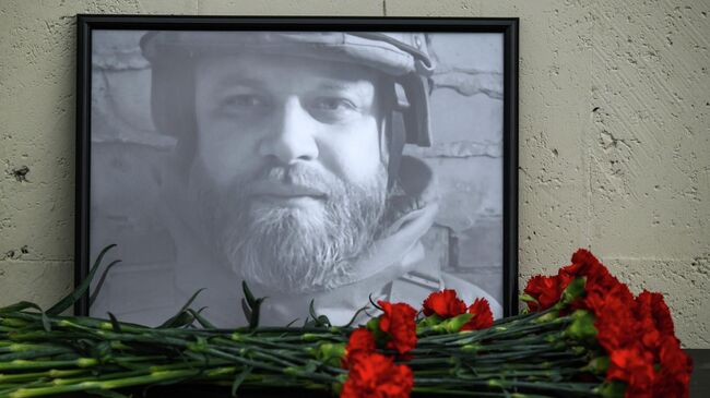 Фотография в память о погибшем военном корреспонденте РИА Новости Иване Зуеве возле здания международного информационного агентства Россия сегодня на Зубовском бульваре в Москве Фотография в память о погибшем военном корреспонденте РИА Новости Иване Зуеве возле здания международного информационного агентства Россия сегодня на Зубовском бульваре в Москве