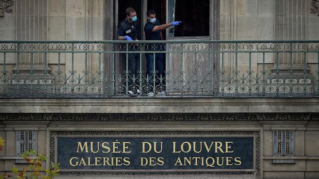 Криминалисты работают в здании Лувра в Париже, Франция