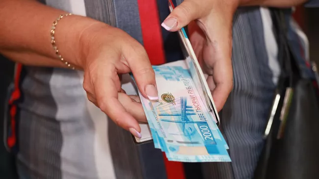 Девушка держит в руках деньги