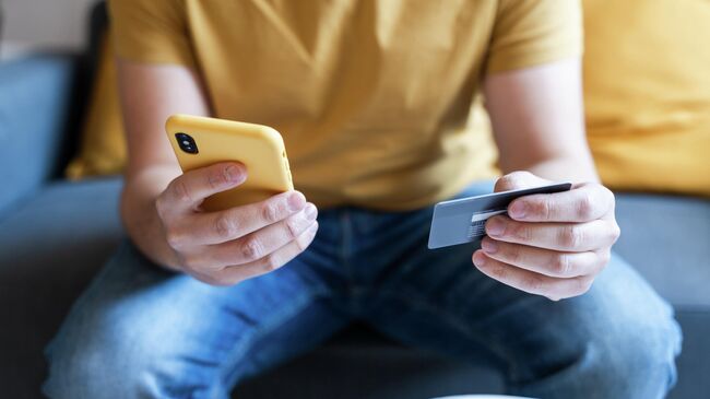 Мужчина со смартфоном и банковской картой