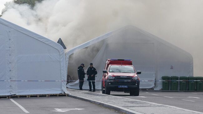 Полицейские во время тушения пожара в лагере сторонников правительства возле здания сербского парламента в Белграде Полицейские во время тушения пожара в лагере сторонников правительства возле здания сербского парламента в Белграде