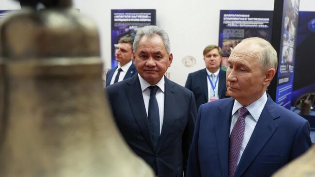Президент РФ Владимир Путин и секретарь Совета безопасности РФ, президент Русского географического общества Сергей Шойгу во время осмотра выставки проектов Русского географического общества в Москве. 23 октября 2025