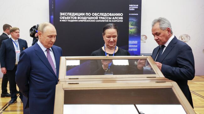 Президент РФ Владимир Путин и секретарь Совета безопасности РФ, президент Русского географического общества Сергей Шойгу во время осмотра выставки проектов Русского географического общества в Москве. 23 октября 2025