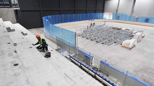 Рабочий в здании ледовой арены 