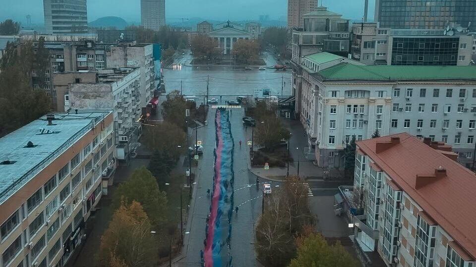 В центре Донецка молодежь развернула флаг ДНР длиной 200 метров ко Дню флага