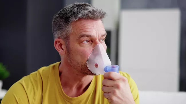 Мужчина использует кислородную маску