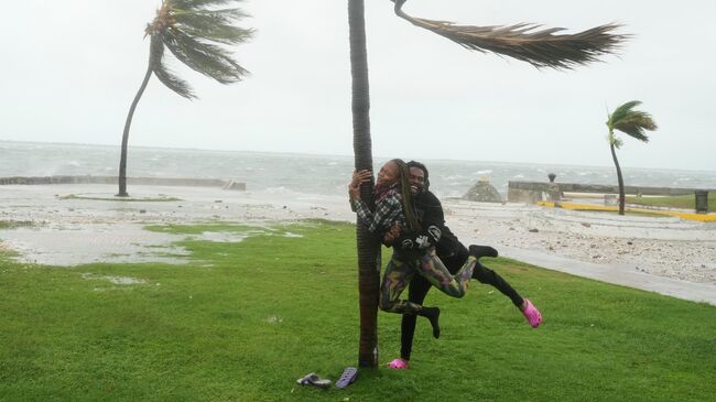 Люди во время приближения урагана Мелисса на побережье Кингстона, Ямайка. 28 октября 2025