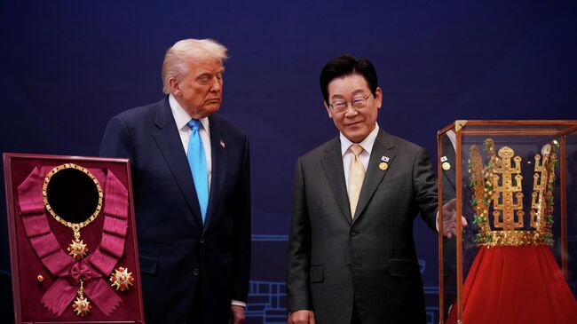 Президент США Дональд Трамп принимает Большой орден мугунхва и копию знаменитой золотой короны периода Силла, врученные ему президентом Южной Кореи Ли Джэ Мёном